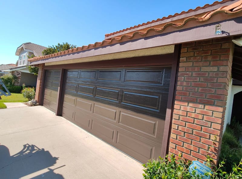 A garage door during full-frame rust removal across the worn surface